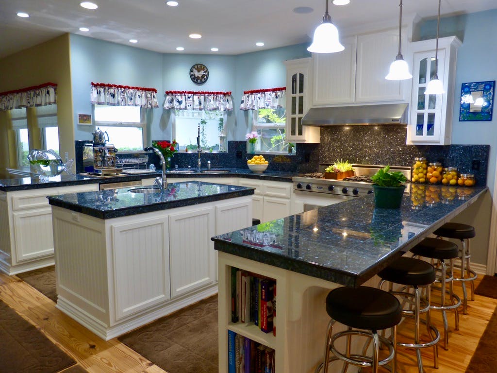 Kitchen with white cabinets, dark countertops, and a breakfast bar with stools