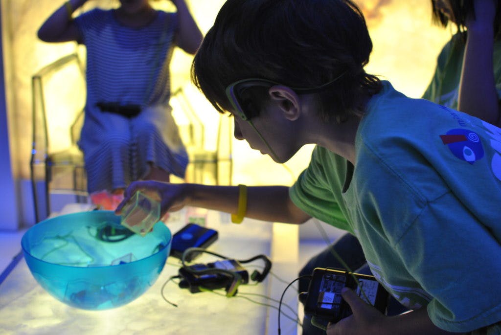 Child interacting with a glowing blue bowl