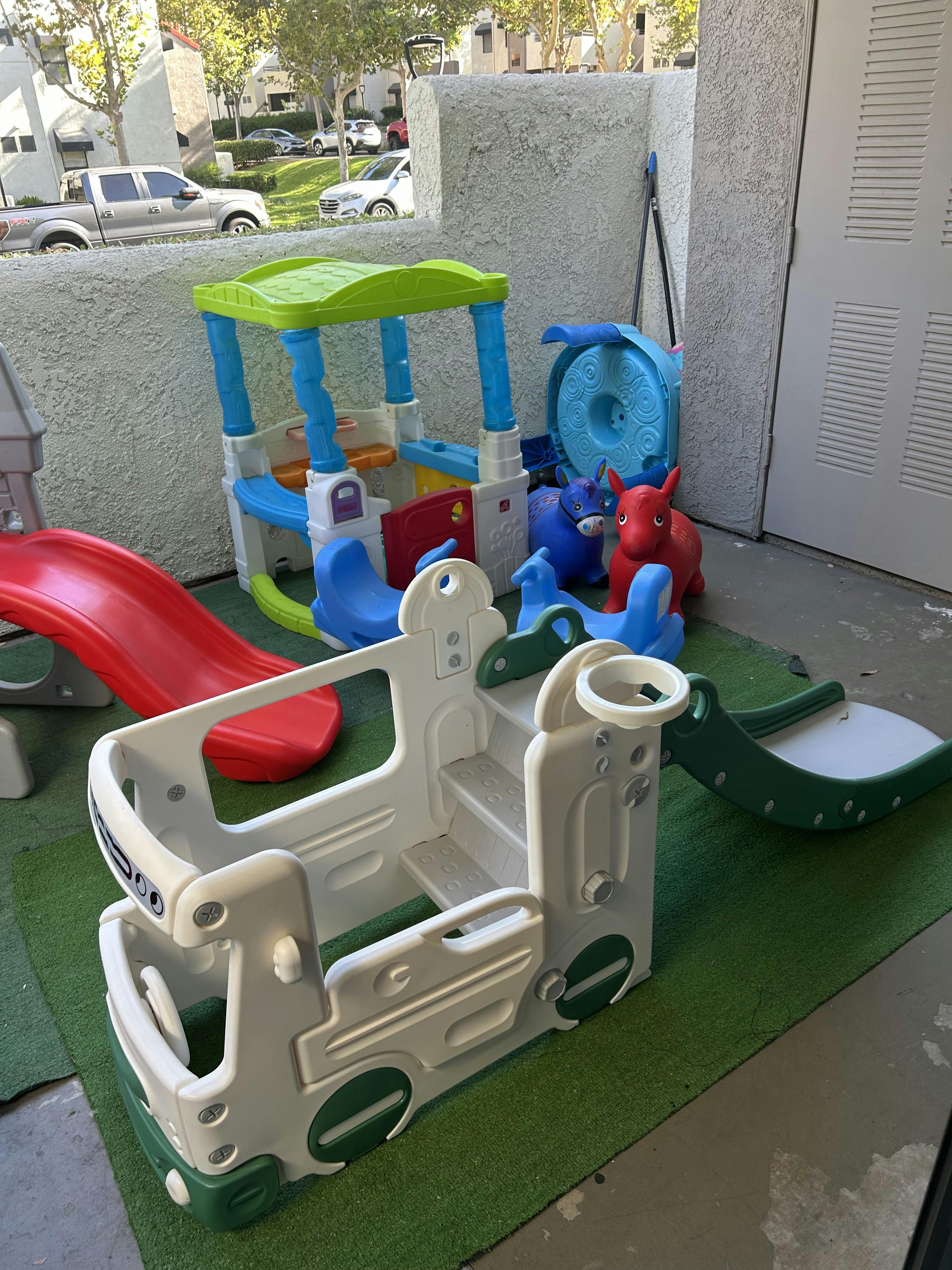 Plastic play structures including a bus, slide, and playhouse