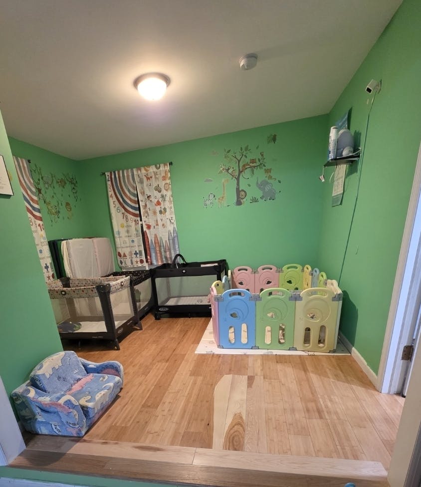 Room with cribs, changing table, and colorful playpen
