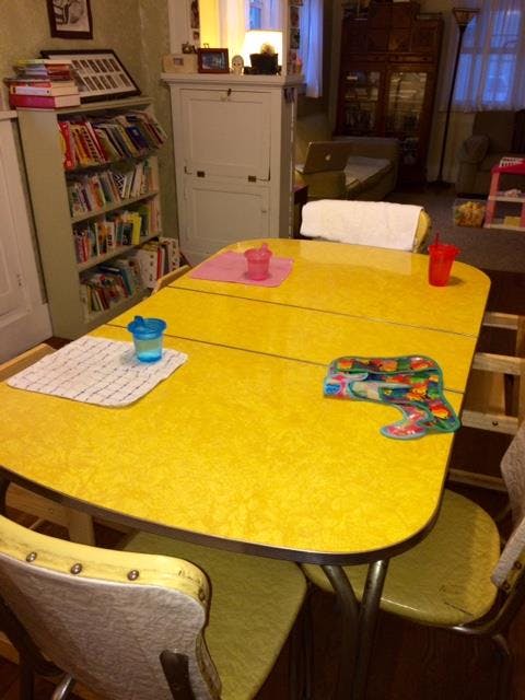 Yellow kitchen table with cups and placemats