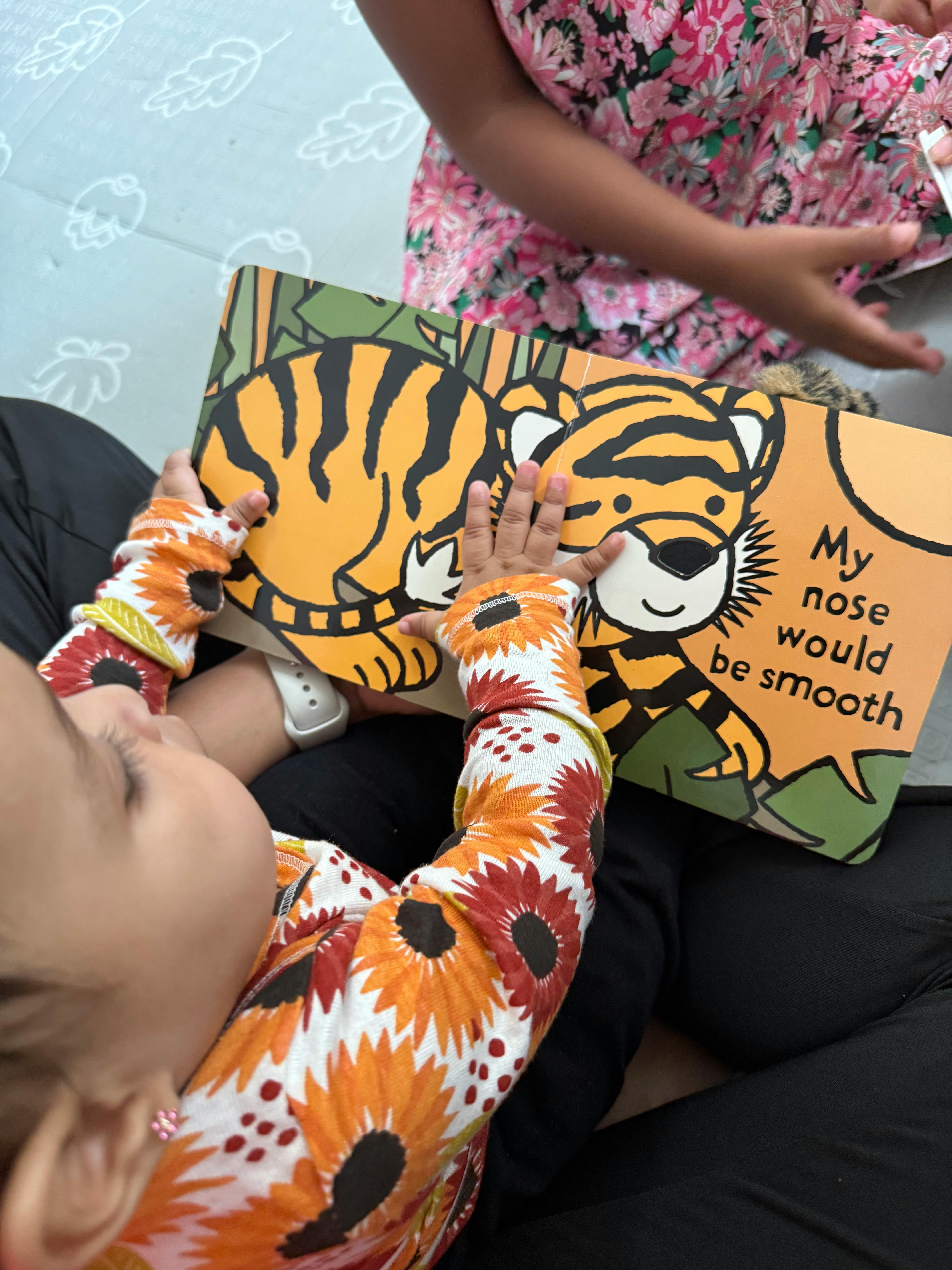 Child holding a children's book featuring a tiger