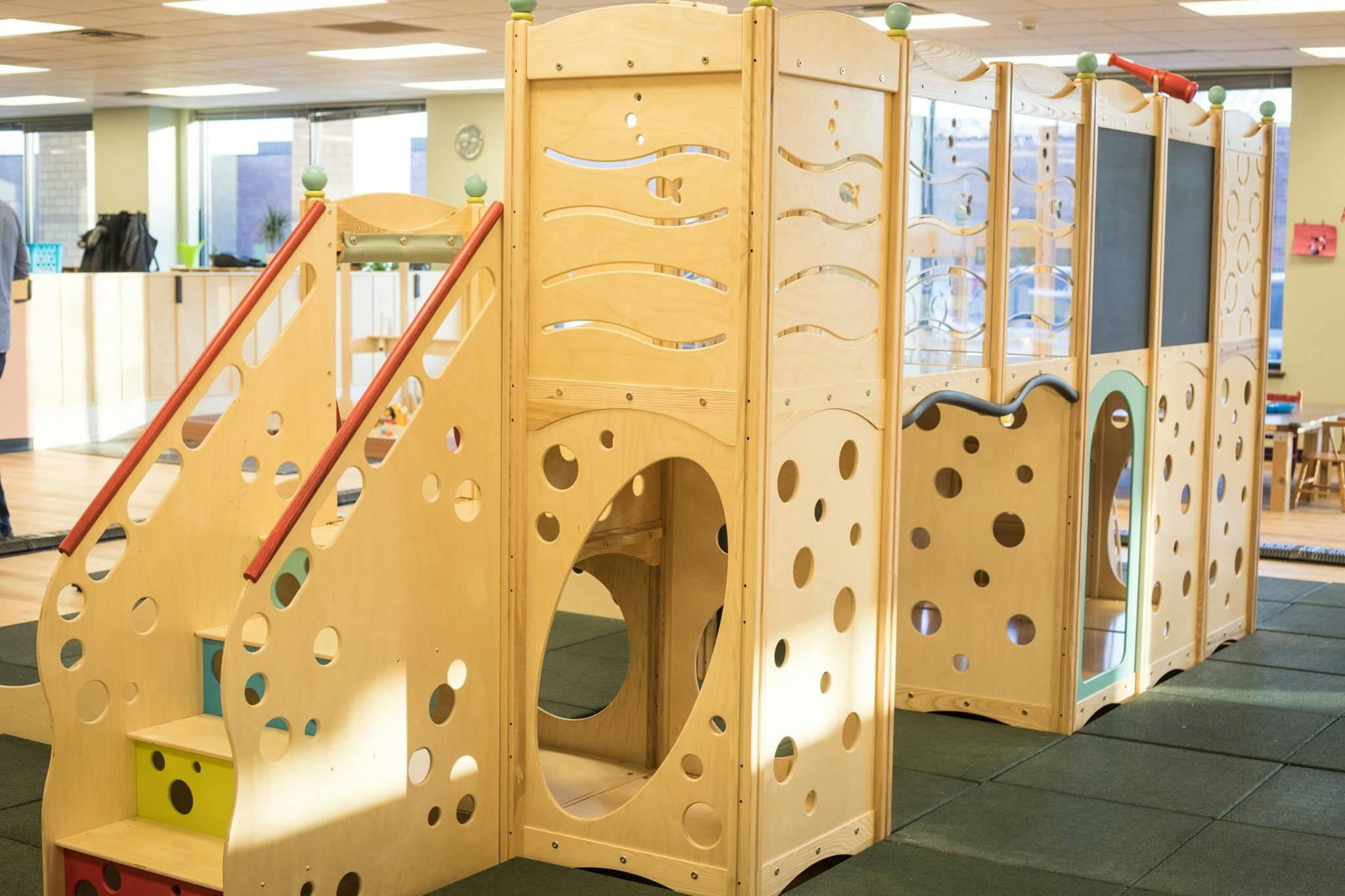 Indoor wooden playground structure with stairs and tunnels