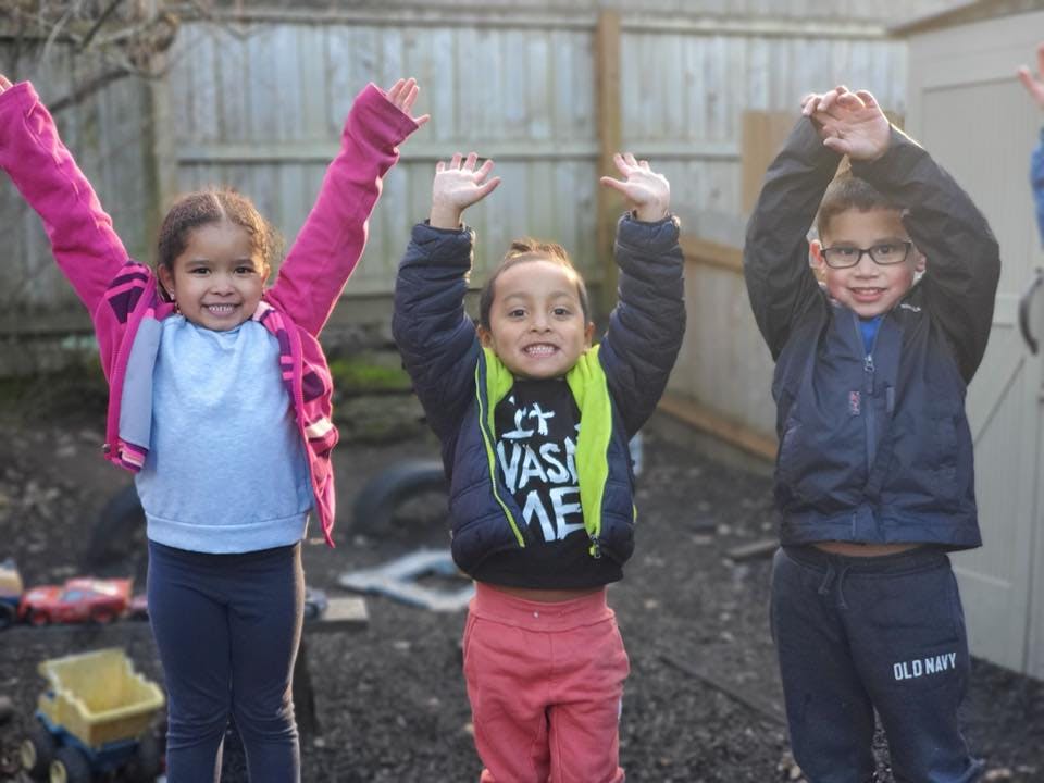 Three children with arms raised