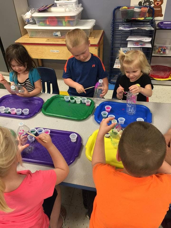 Children at a table with trays and small cups