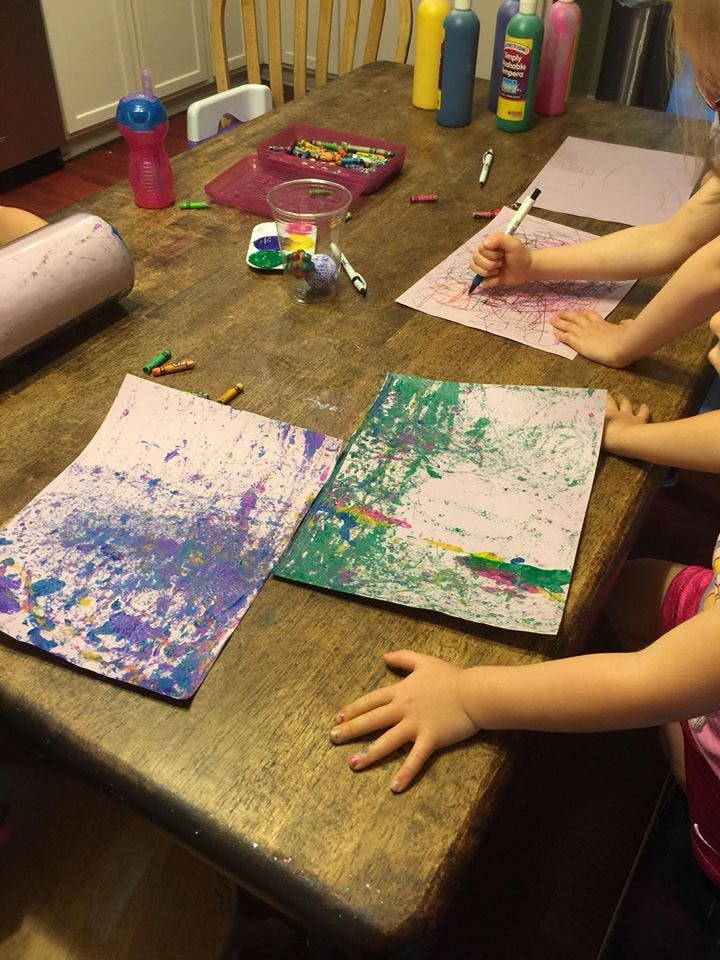 Children drawing and painting at a table