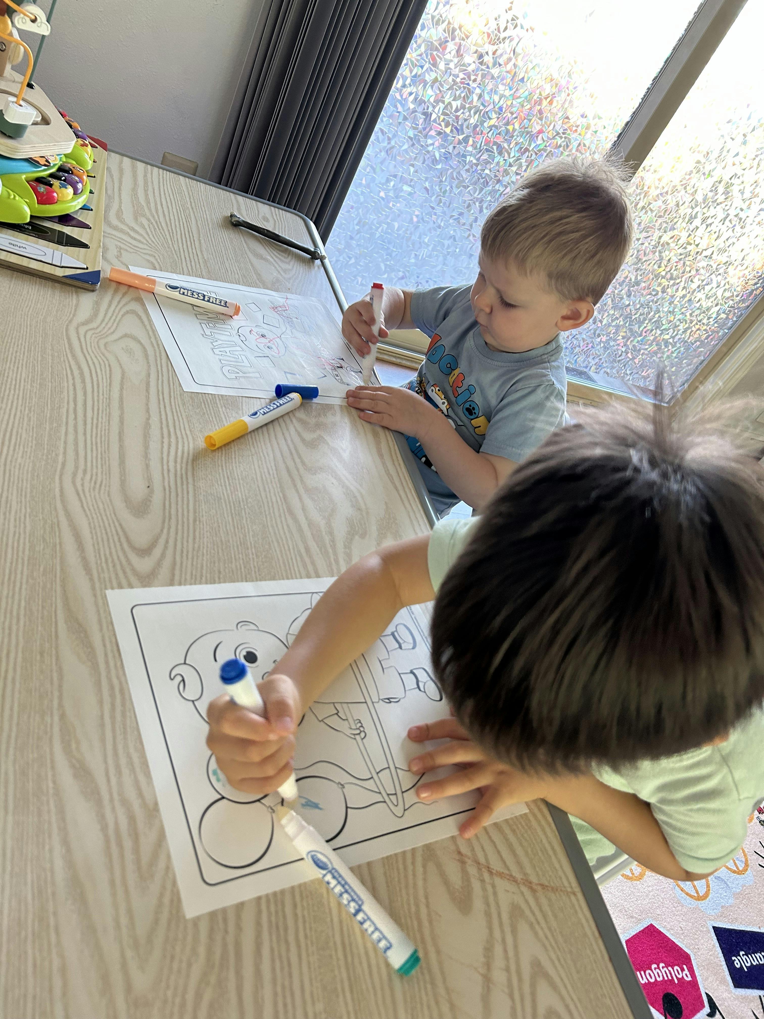 Two children coloring at a table