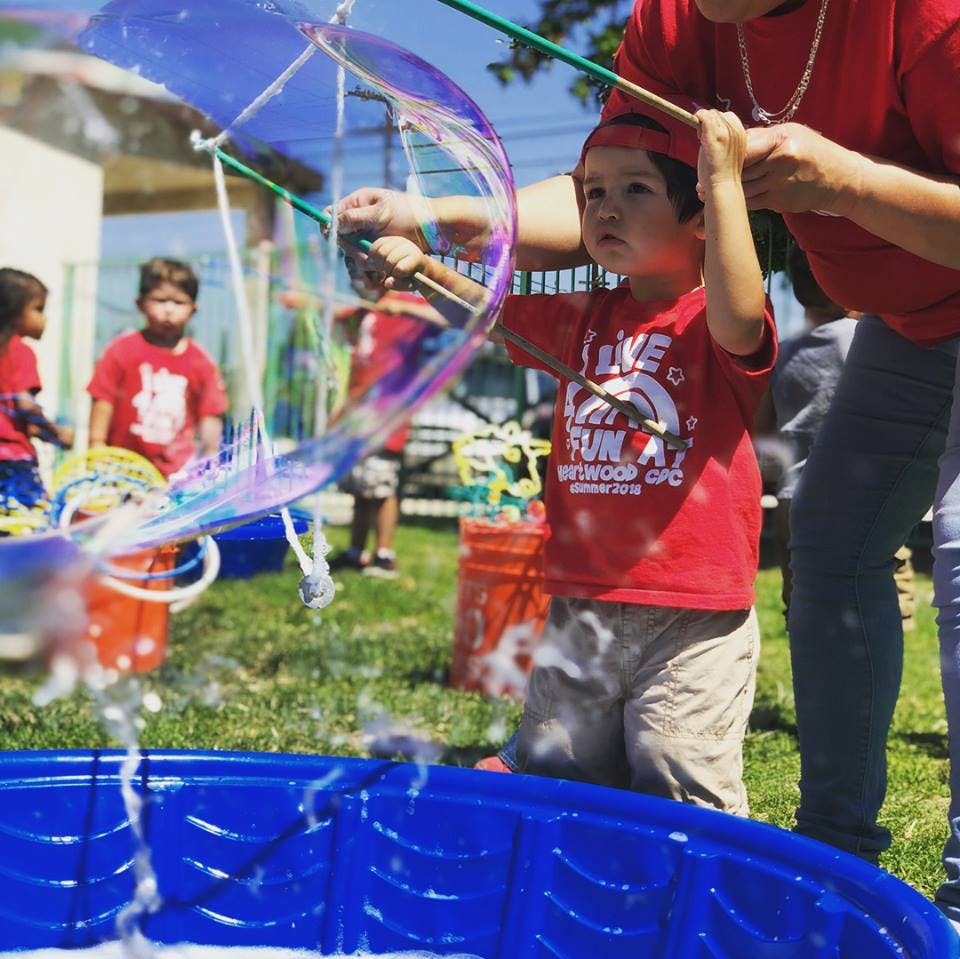 Child making large bubbles with a bubble wand
