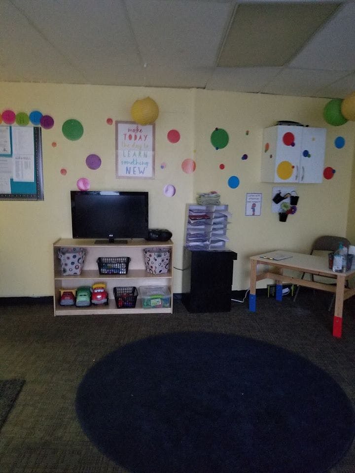 Classroom with a television on a shelf, a small table, and colorful wall decorations