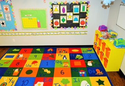 Colorful classroom with alphabet rug and shape posters