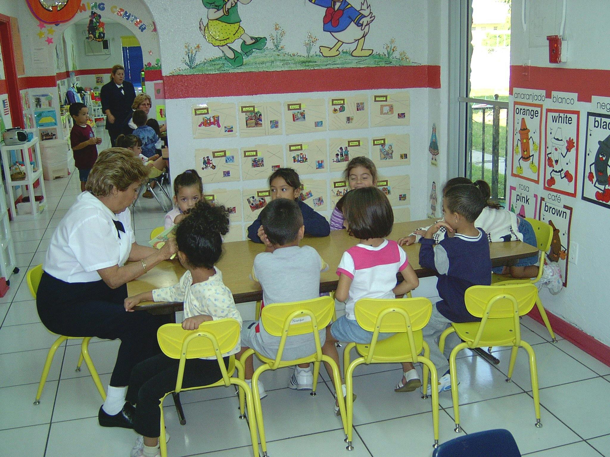 Adult and children sitting at a table in a classroom