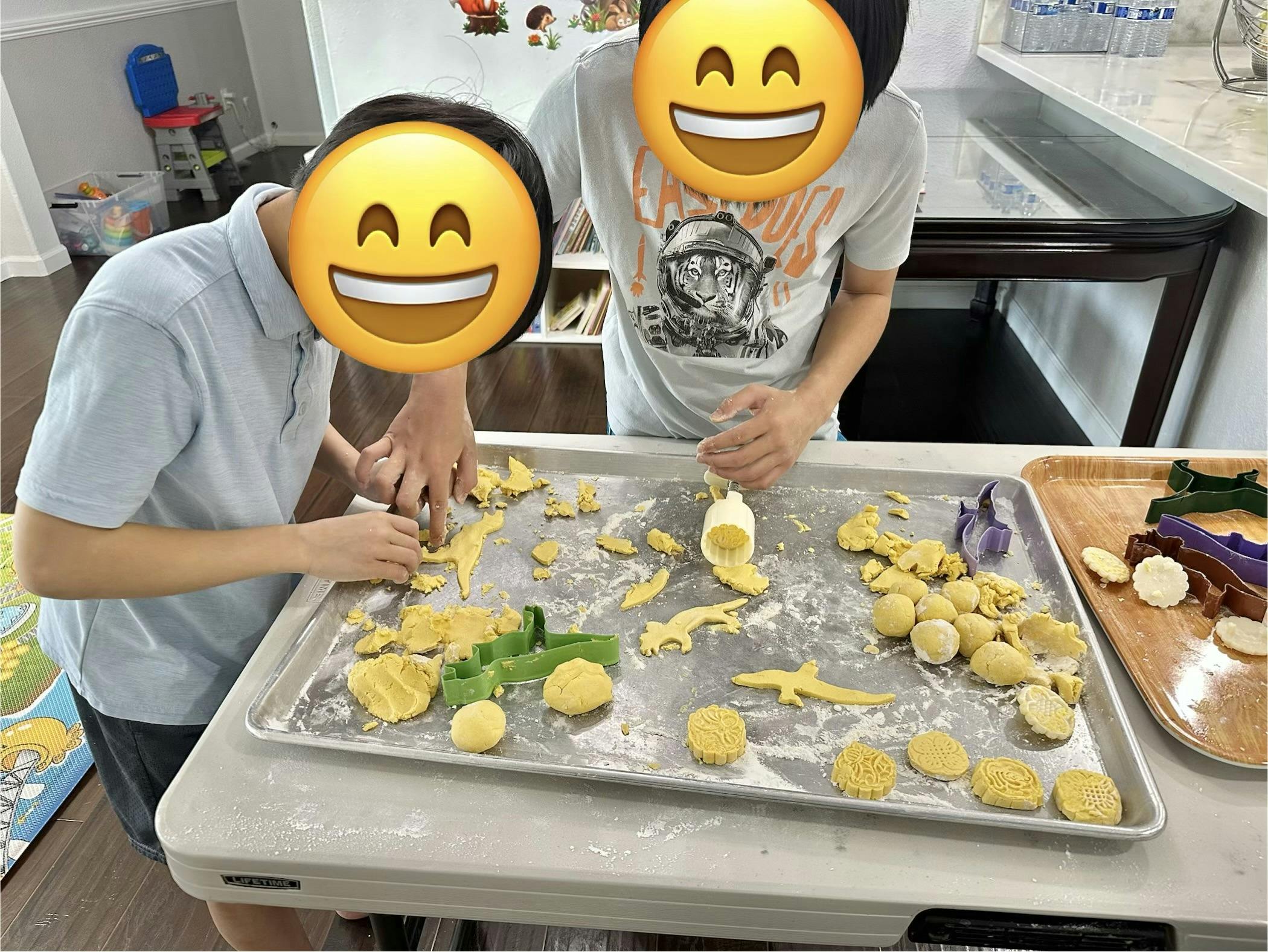 Two people making mooncakes and shaping dough with cookie cutters