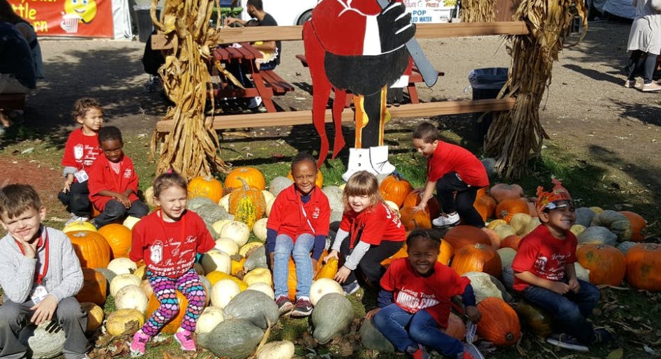 Children sitting among pumpkins and gourds