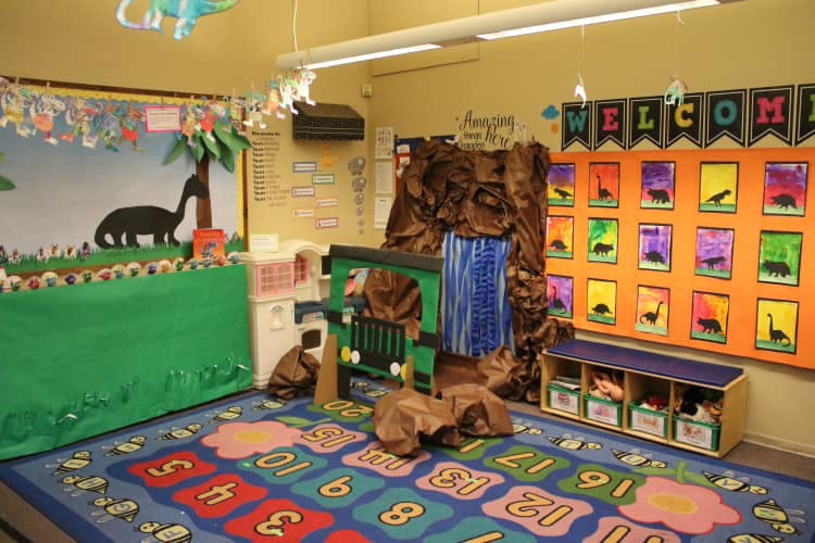 Classroom with dinosaur decorations and a number rug