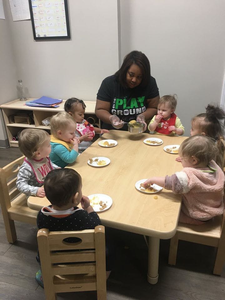 Person serving food to children at a table