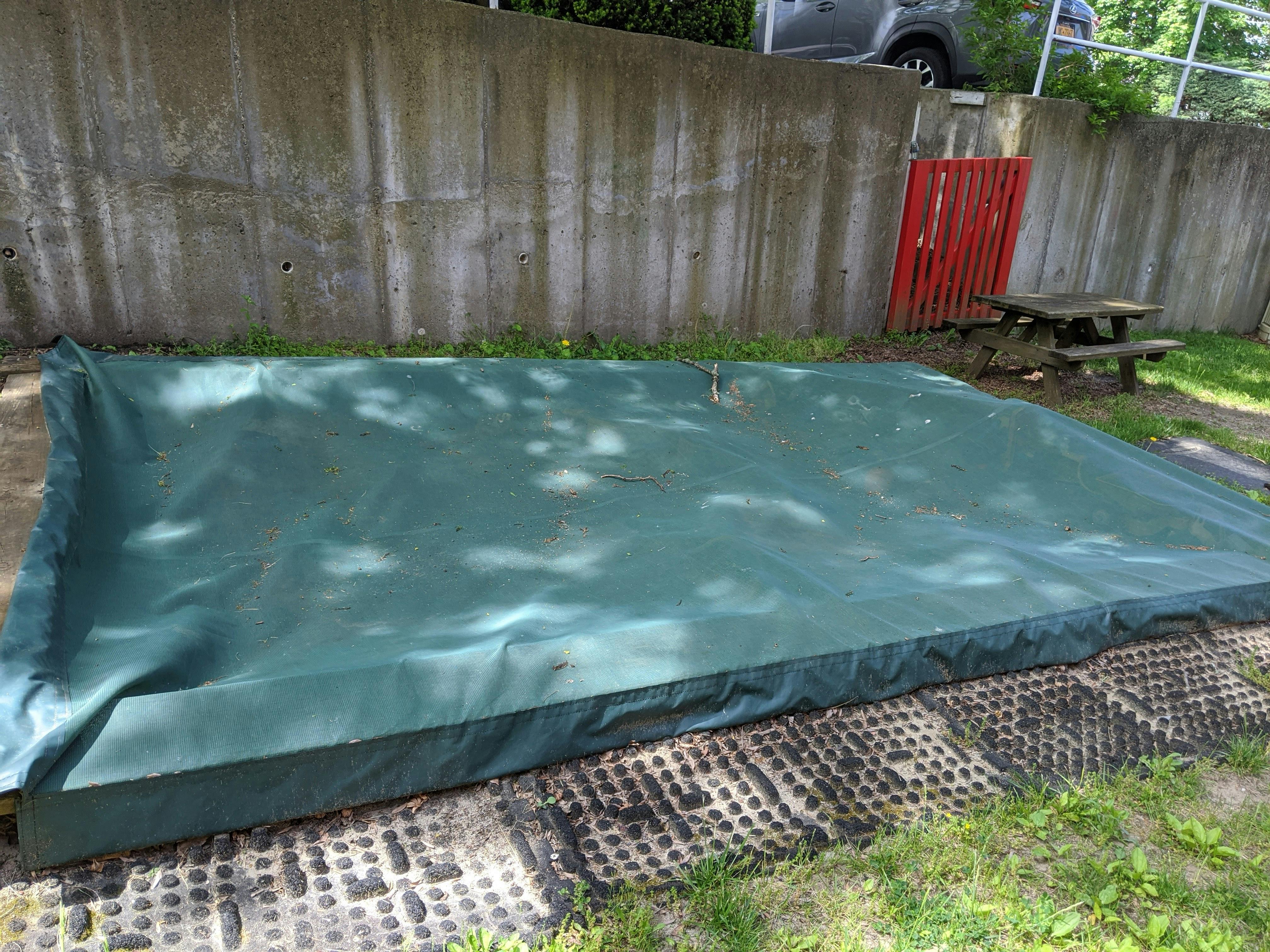 Green tarp covering a rectangular area on the ground