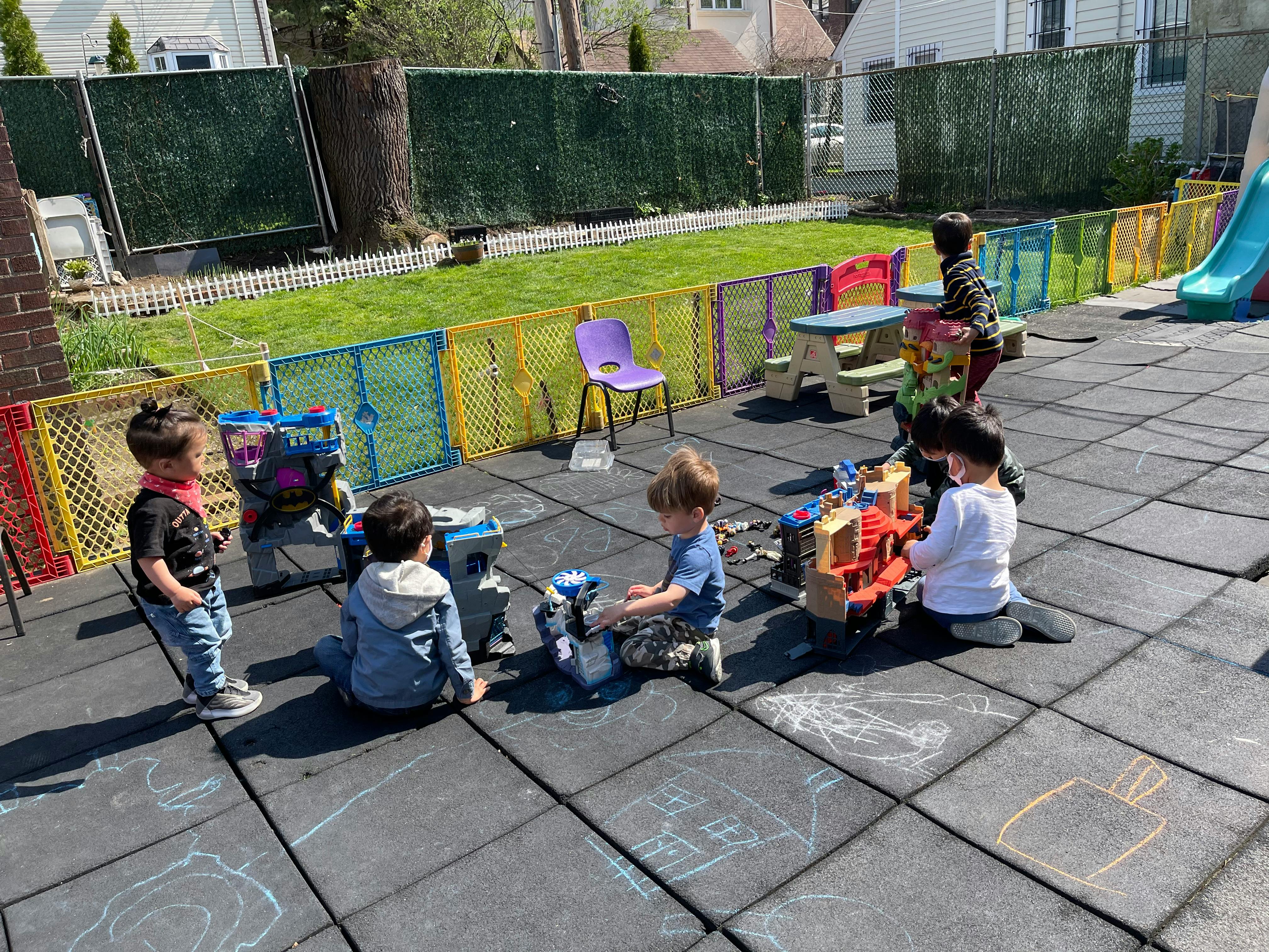 Children playing with toys on a paved outdoor area