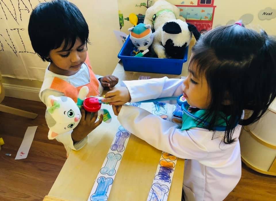 Two children playing with toys at a table