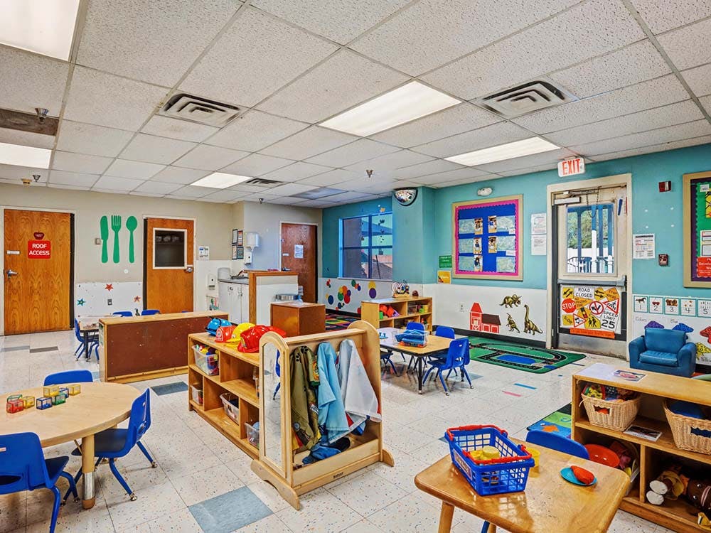 Colorful classroom with small tables, chairs, and play areas