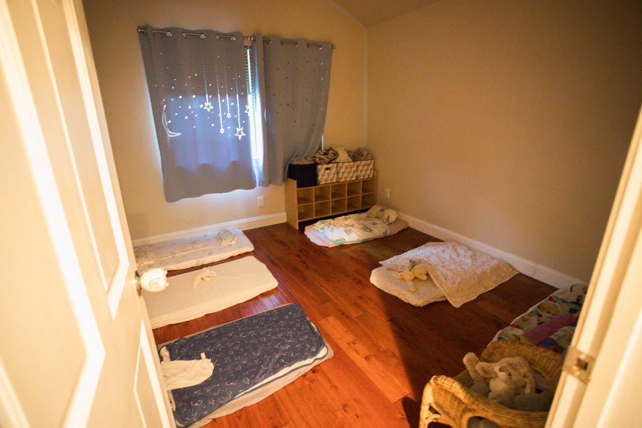 Several floor mats with blankets laid out in a room