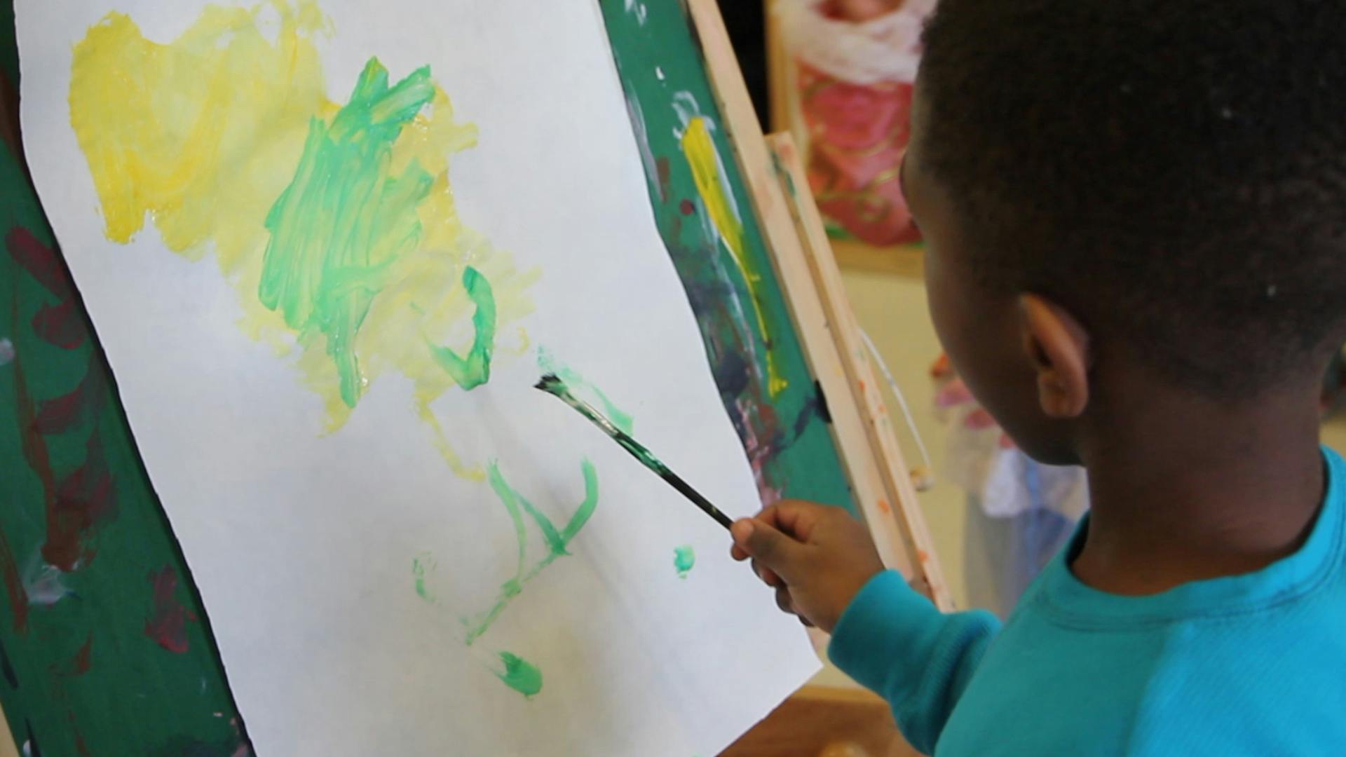 Child painting on an easel