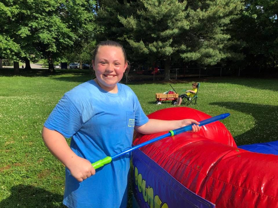 Person holding a water toy next to an inflatable