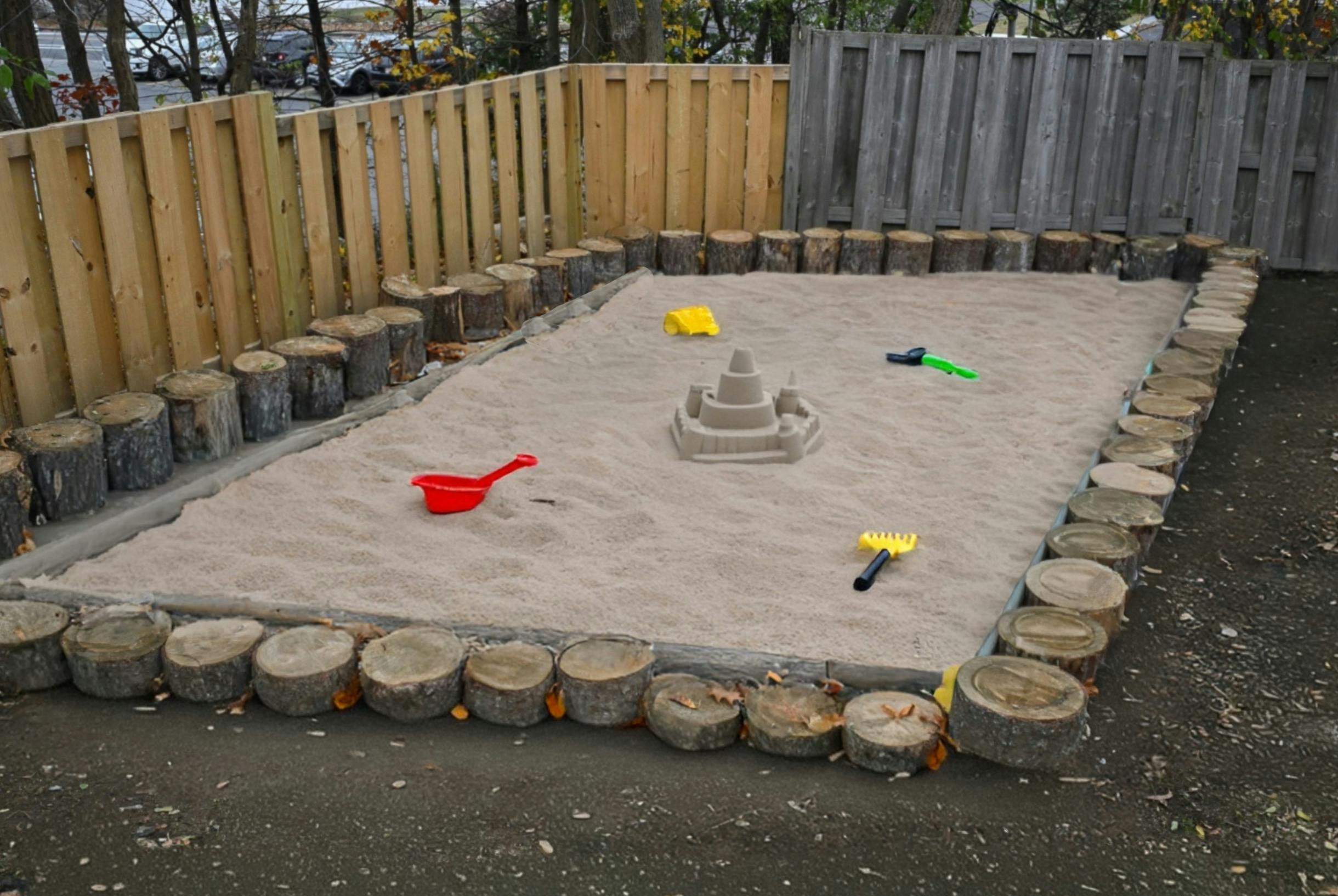 Sandbox with a sandcastle and sand toys