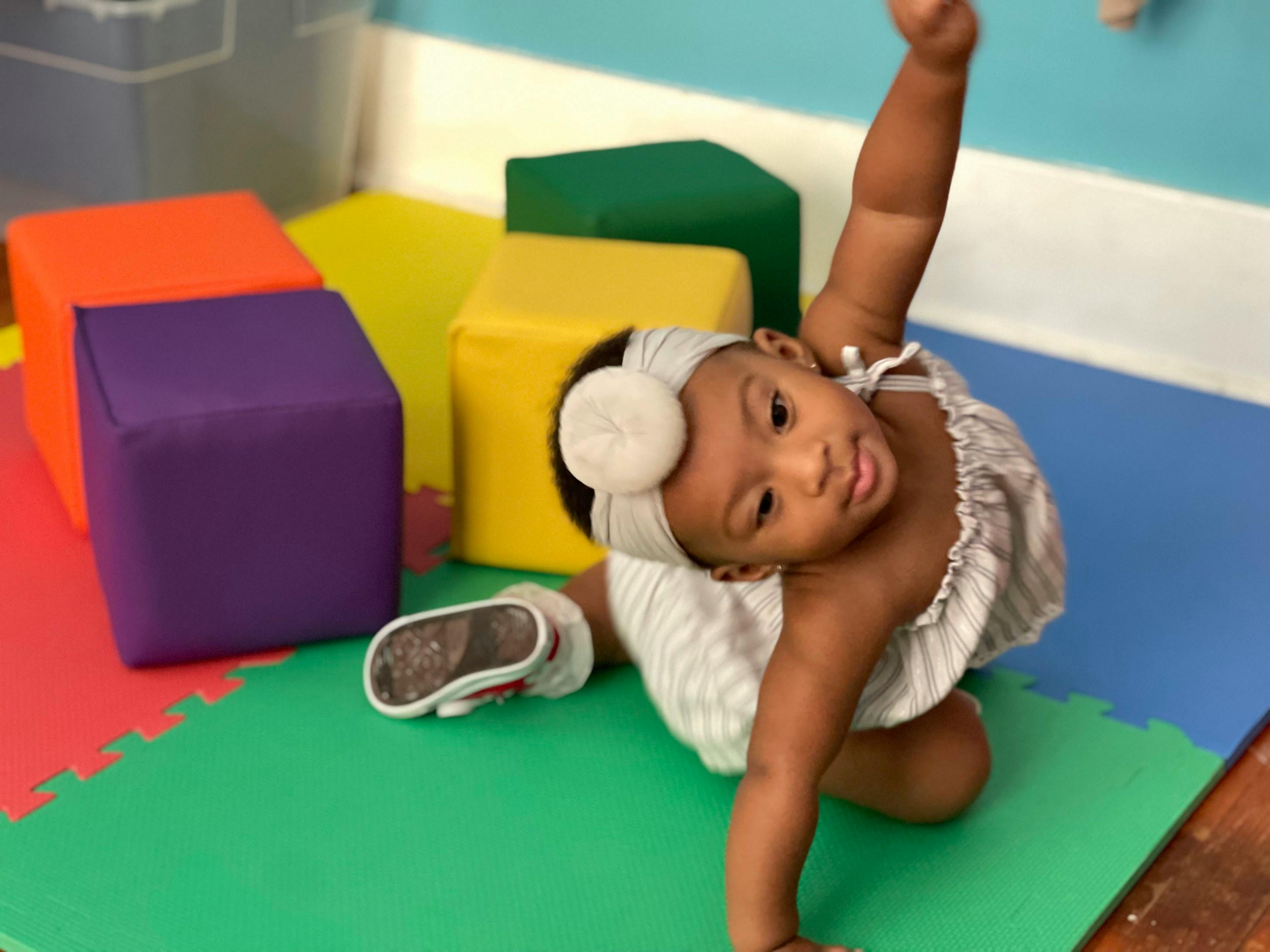 Child crawling on a colorful mat with soft blocks