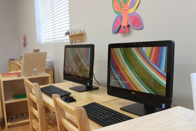 Two computers with keyboards on a wooden desk