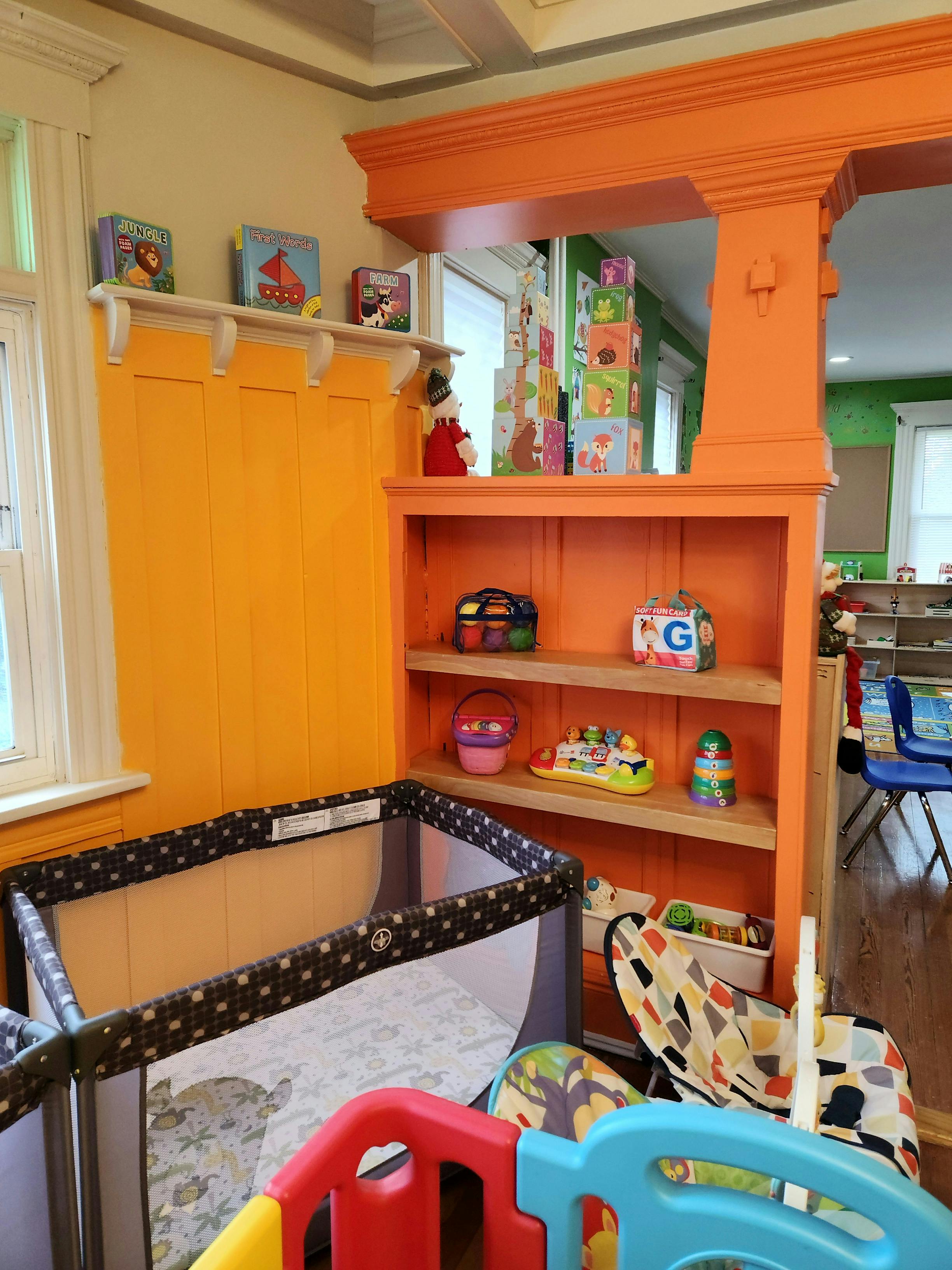 Playpen and shelves with toys in a childcare room
