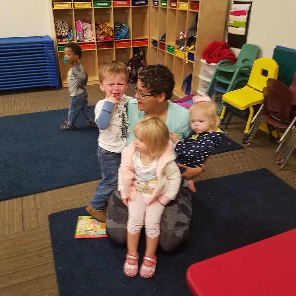Adult with three children in a classroom