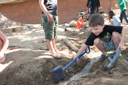 Child digging in dirt with a shovel