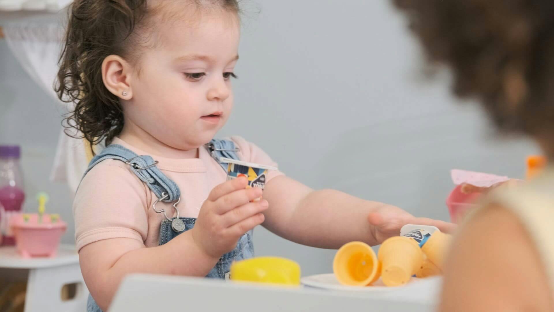Child playing with toy food at a small table