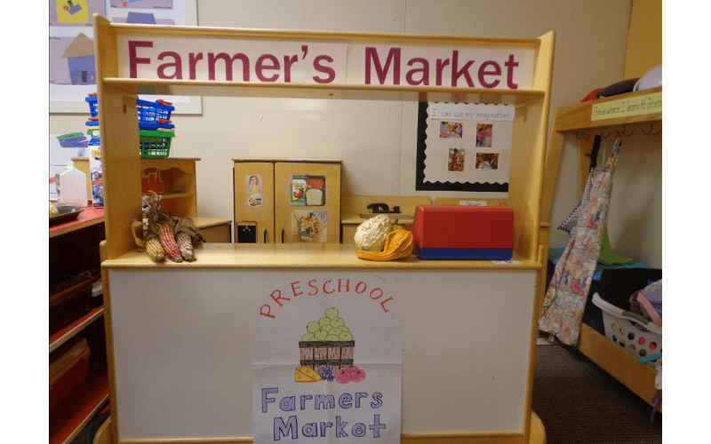 A play stand with a sign that reads "Farmer's Market"