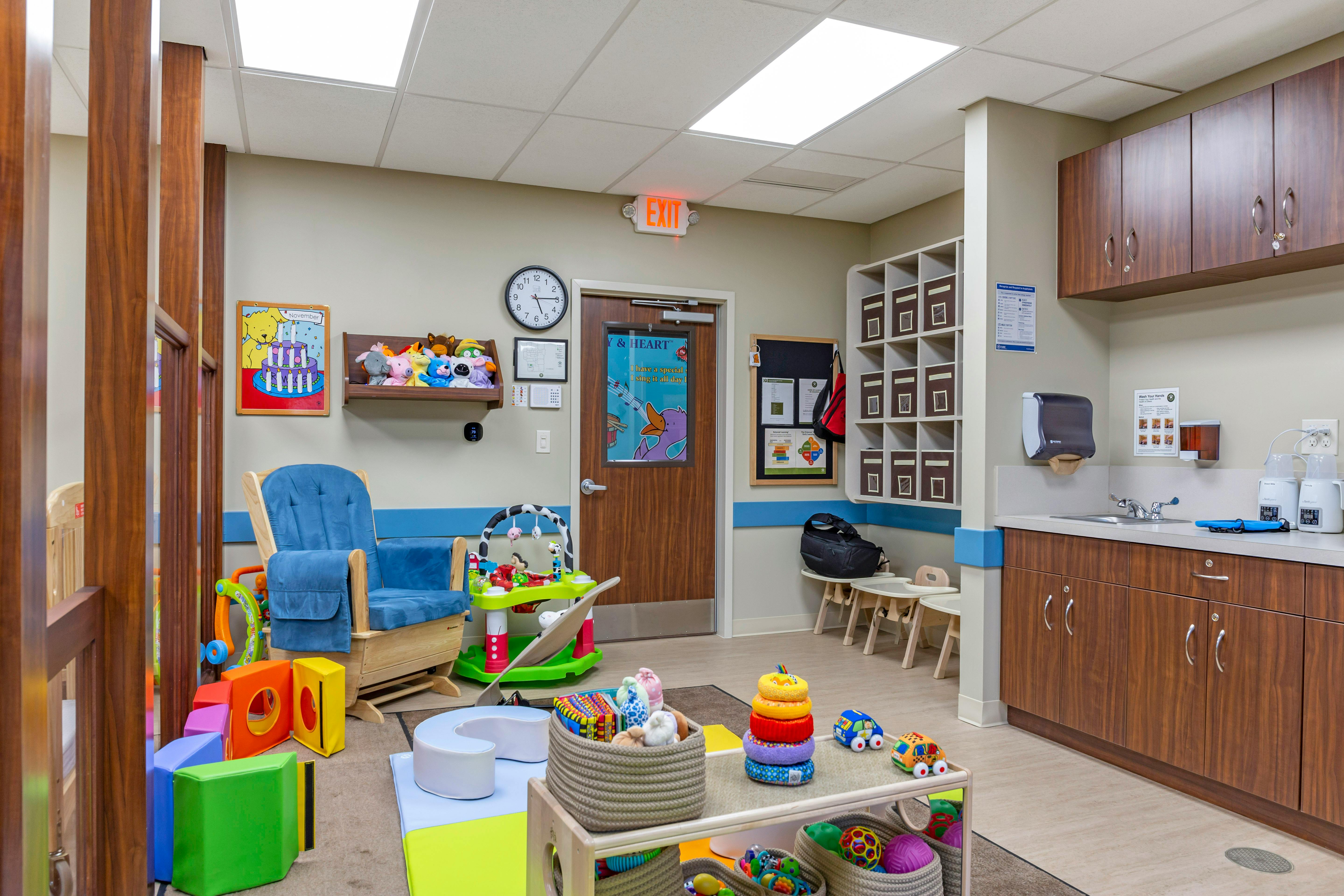 Childcare classroom with toys, rocker, sink, and storage cubbies
