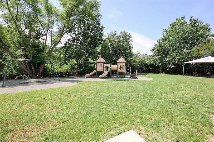 Playground with swings, slides, and climbing structures on grass