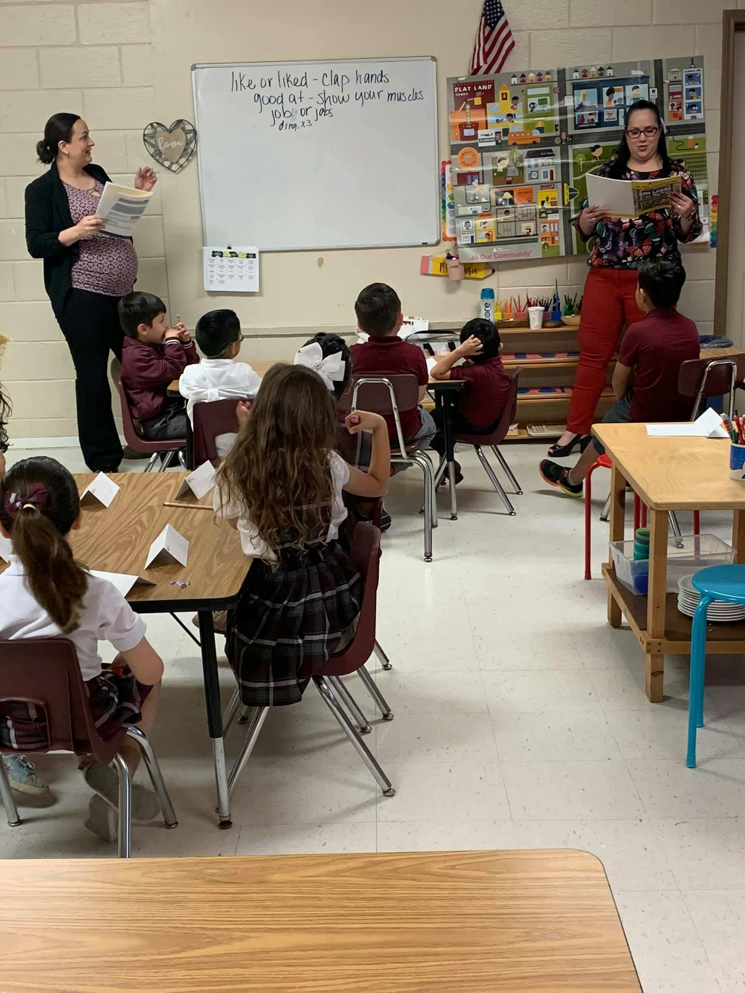 Two people teaching children in a classroom