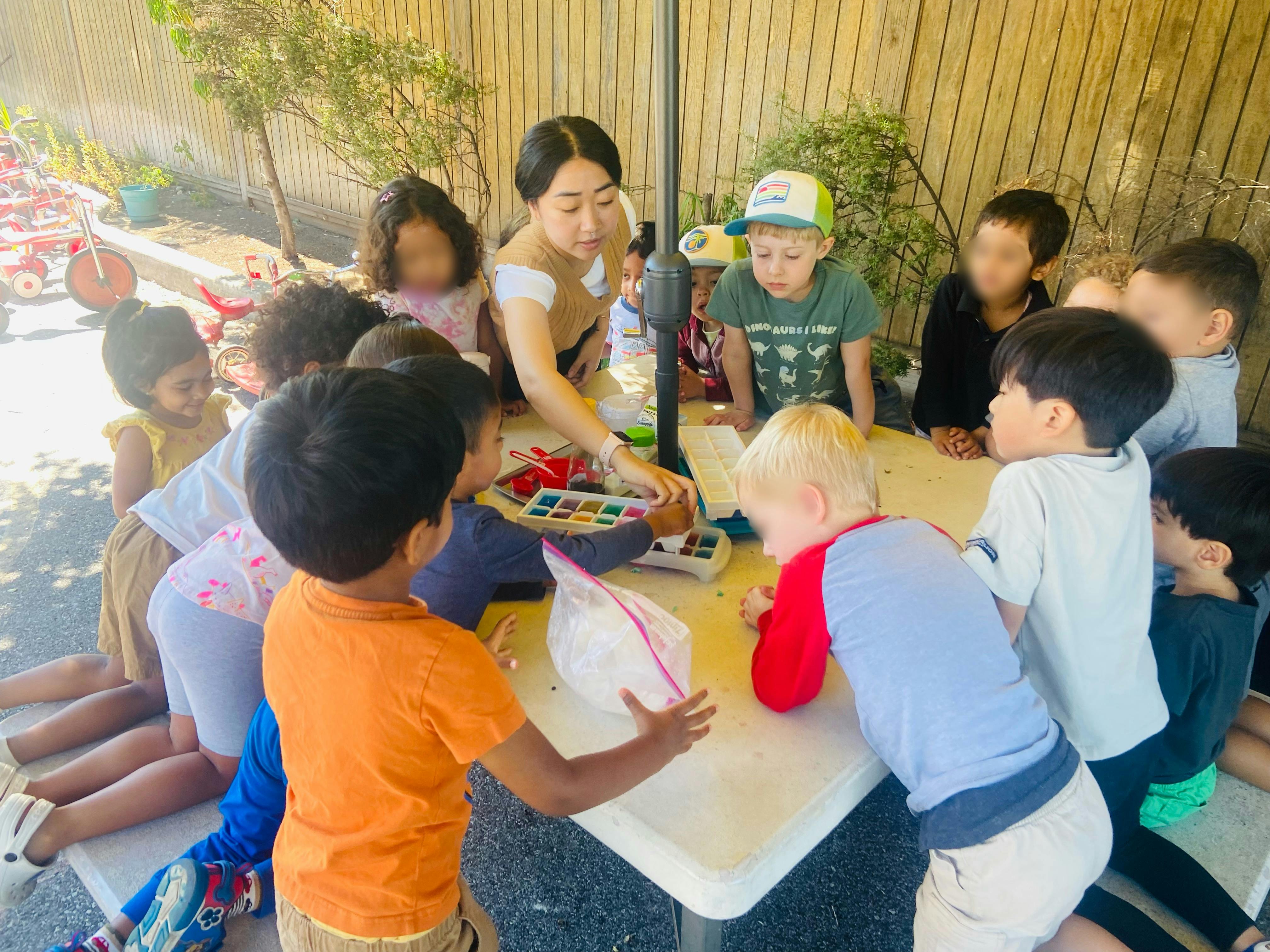 Adult and children gathered around a table with art supplies