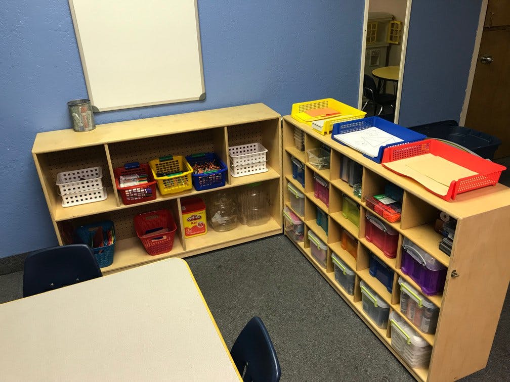 Classroom with shelves of supplies and a whiteboard