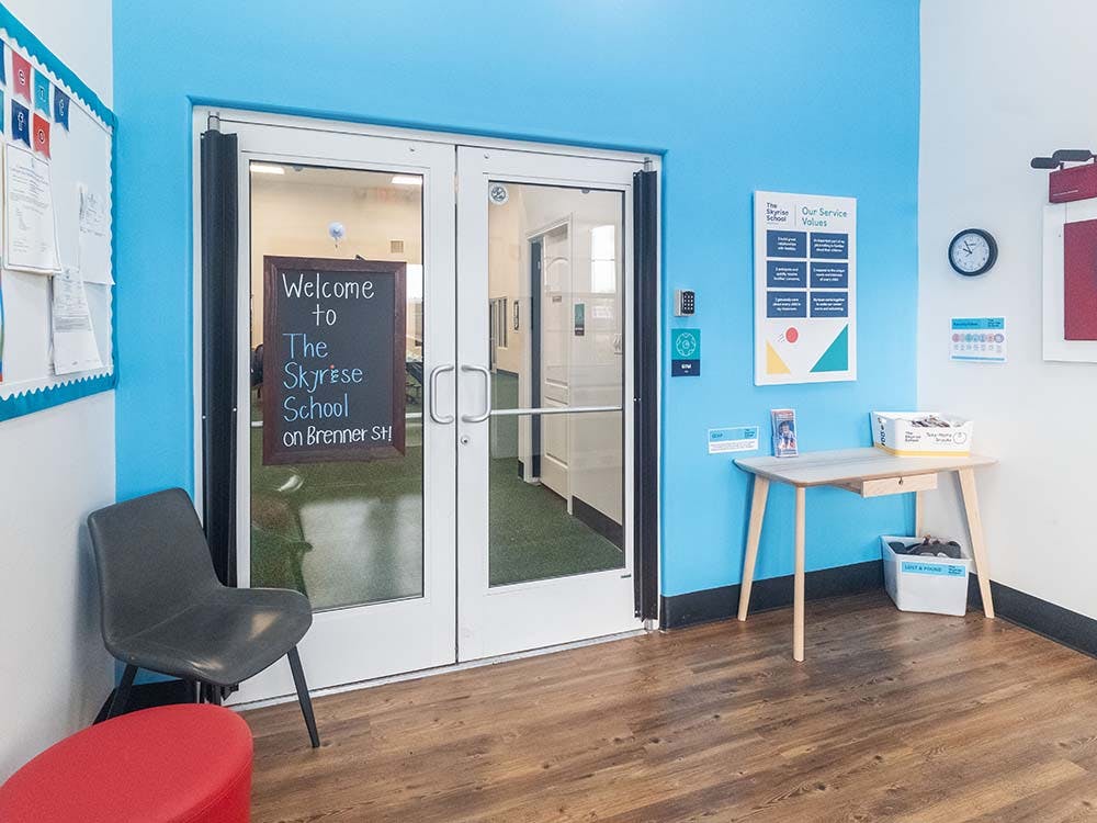 Entrance to a school with a chalkboard sign and blue walls