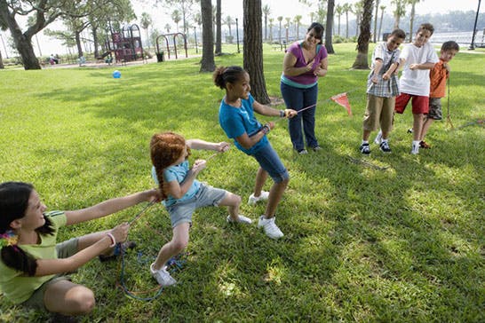 Children playing tug-of-war in a park