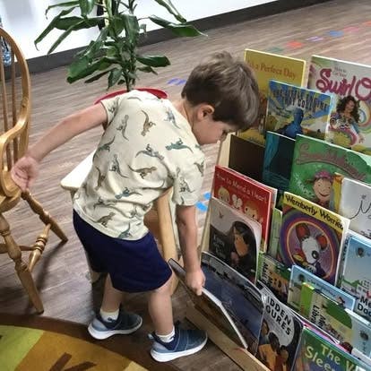 Child selecting a book from a shelf