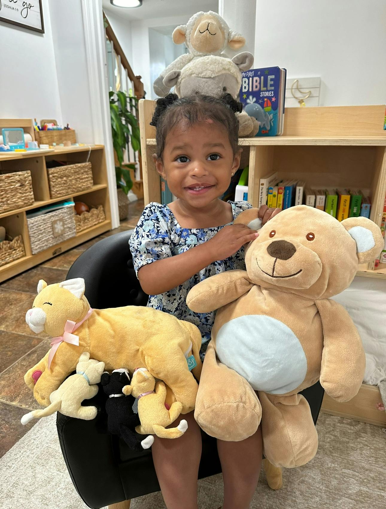 Child sitting with multiple stuffed animals