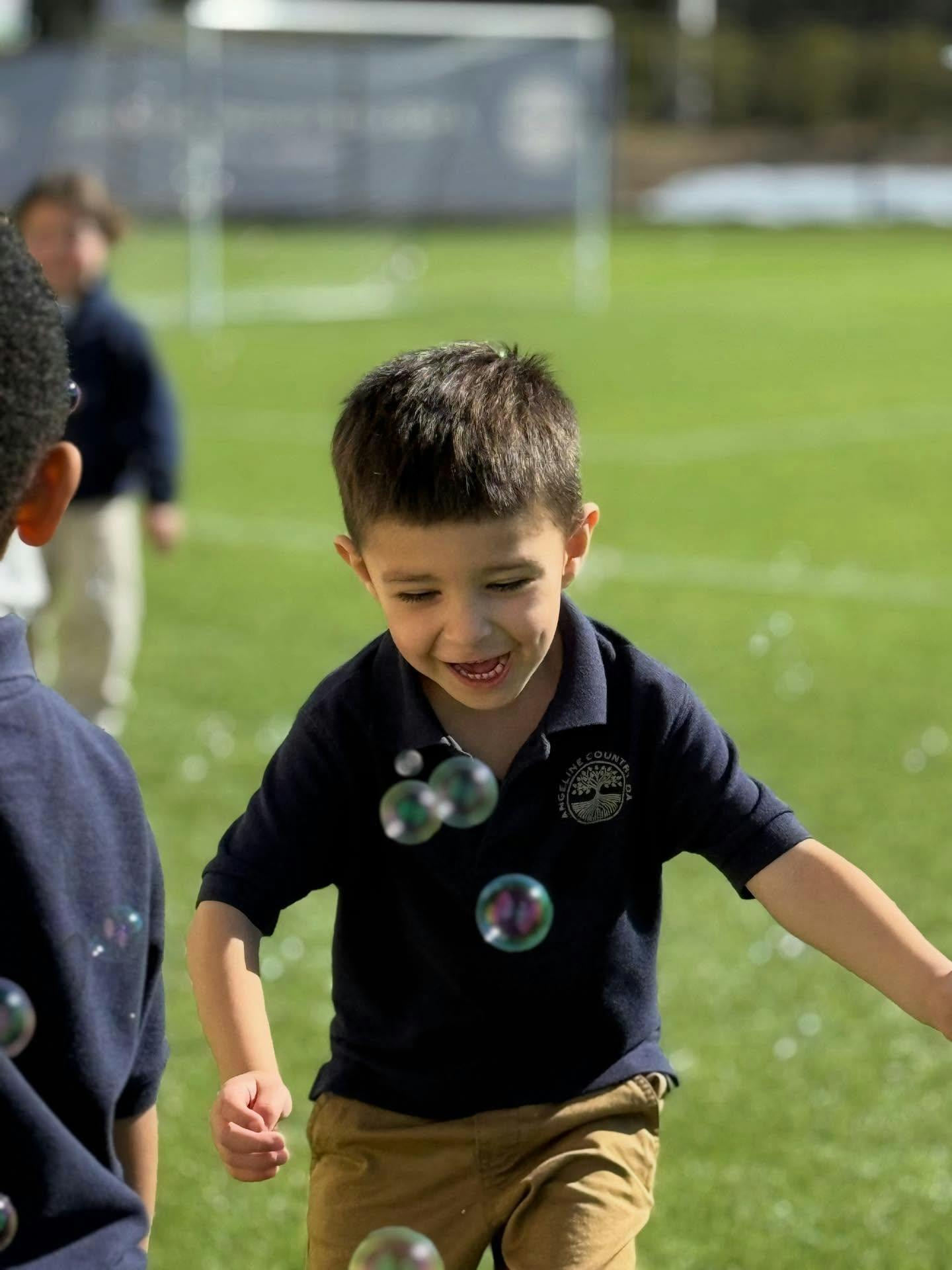 Child playing with bubbles on a field