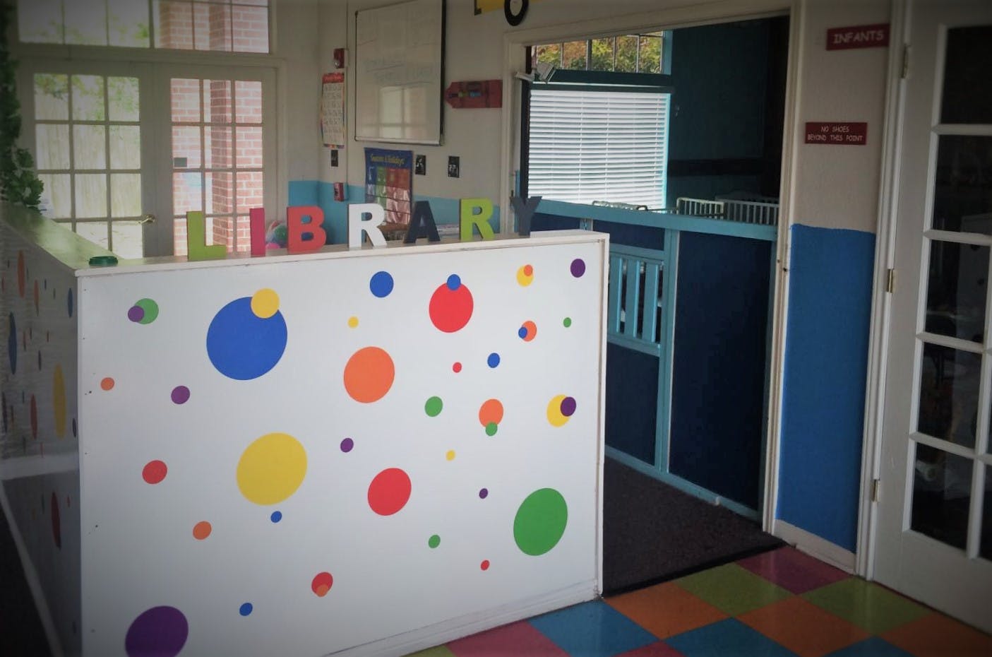 Colorful polka dot wall with "LIBRARY" sign in background