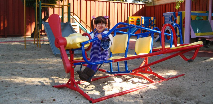Child on a playground airplane ride shaped like an airplane