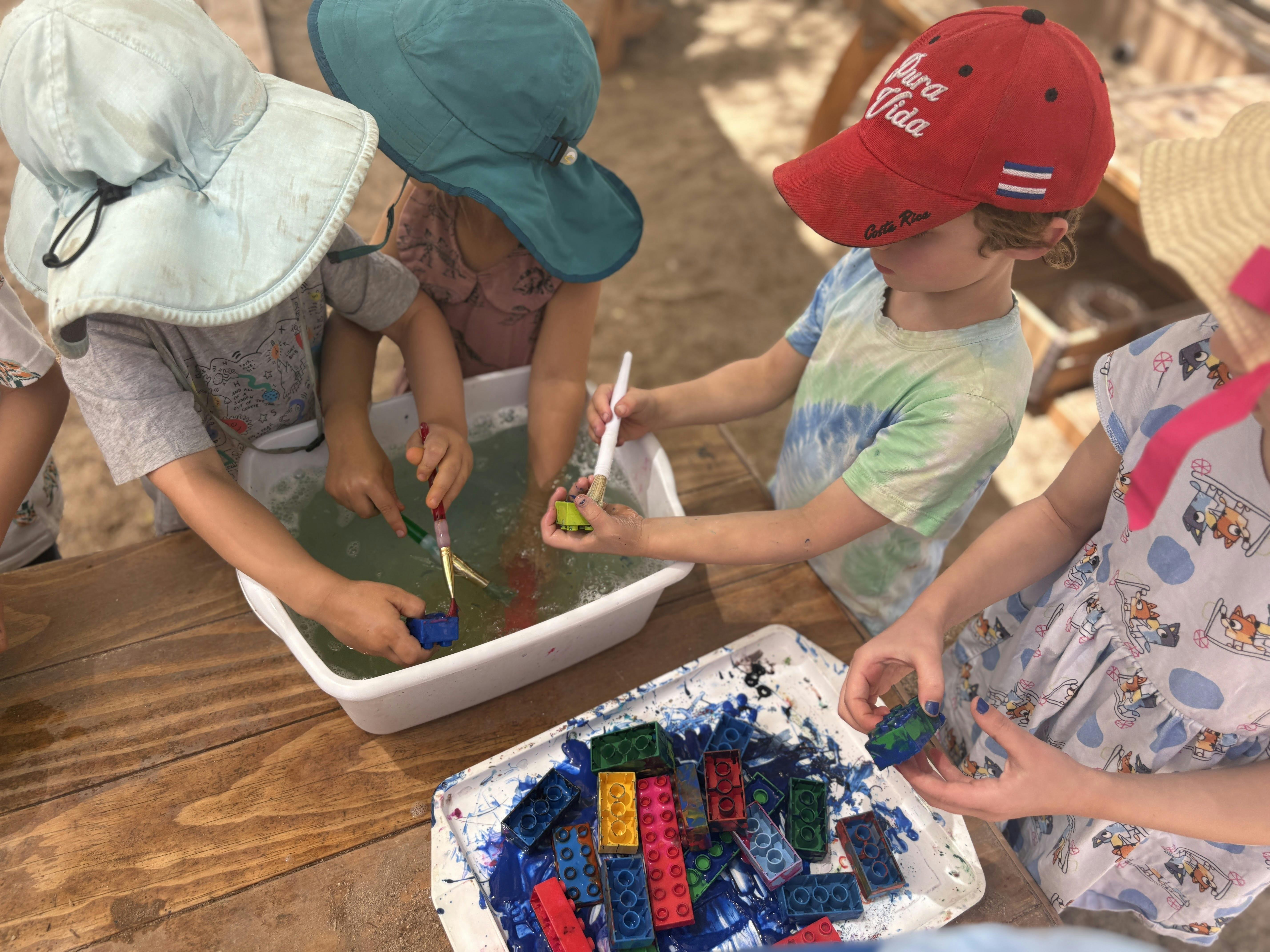 Children playing with water and toys in a bin