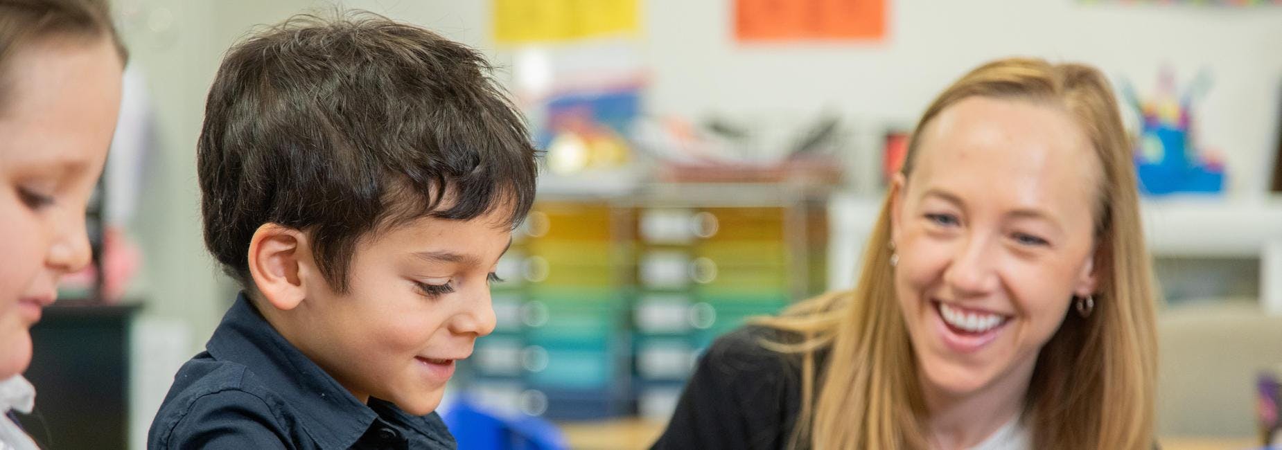 Adult and two children in a classroom