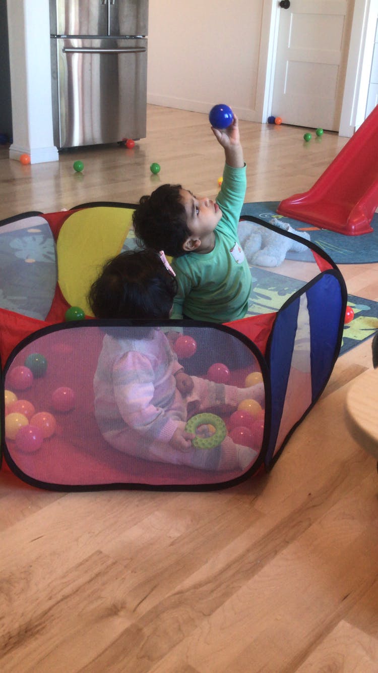 Two children playing in a ball pit