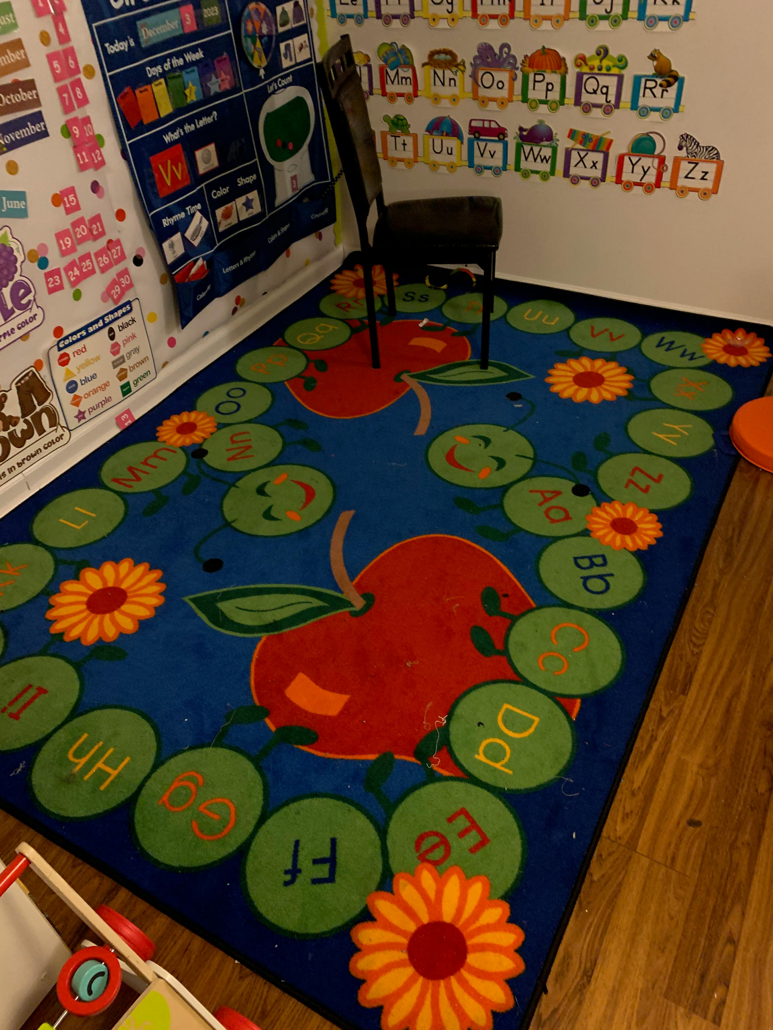 Classroom rug with apples, flowers, and alphabet letters